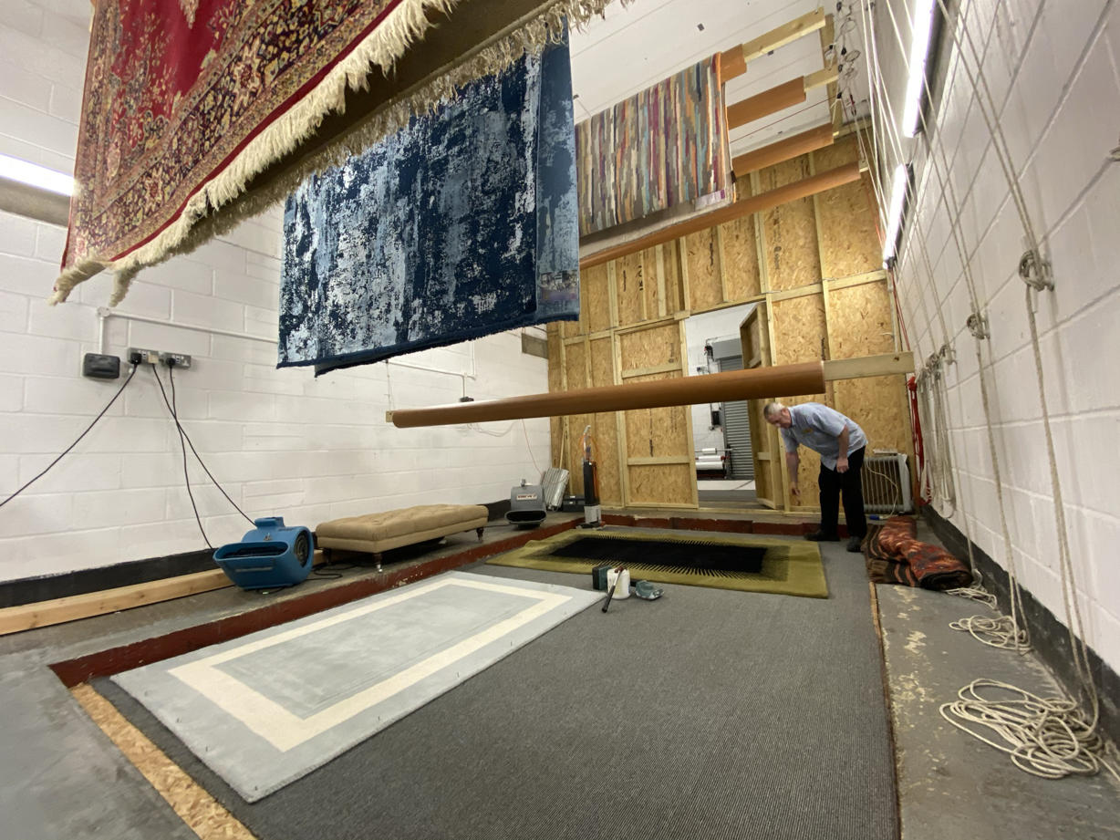Rugs hanging from ceiling drying after being cleaned